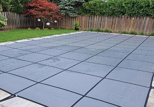 Covered inground swimming pool with custom safety cover in Toronto